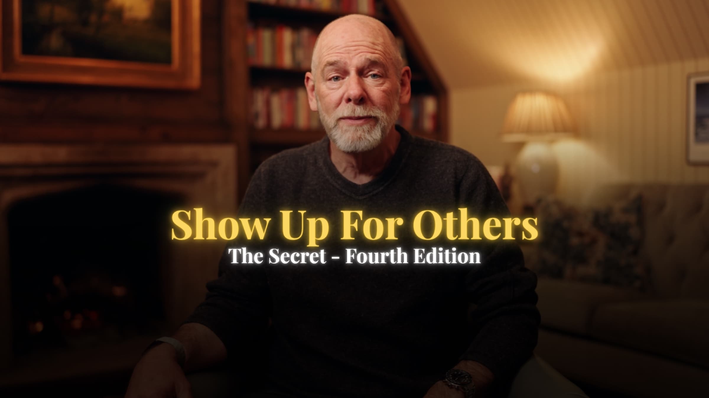 A title card from the book launch campaign for The Secret, Fourth Edition, reading Show Up For Others over Mark Miller speaking to camera beside a lit fireplace.